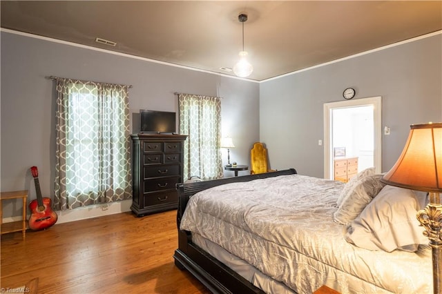 bedroom featuring wood-type flooring and ornamental molding