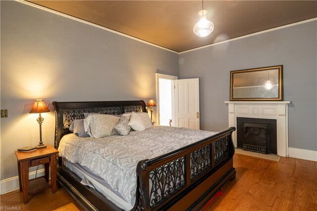 bedroom with wood-type flooring and ornamental molding