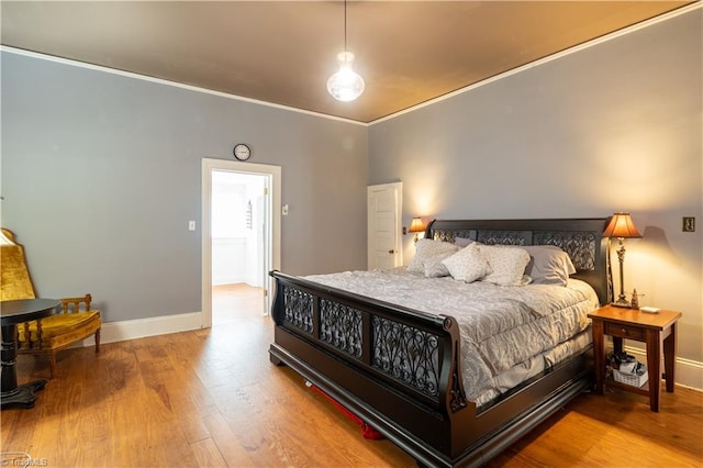 bedroom with ornamental molding and wood-type flooring