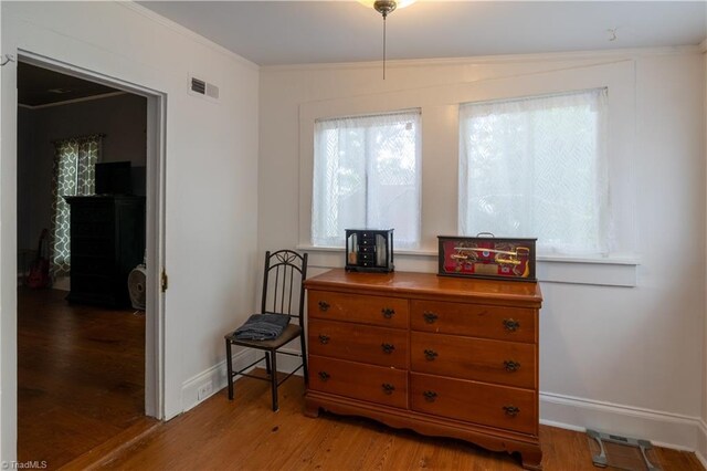 interior space with ornamental molding and light hardwood / wood-style flooring