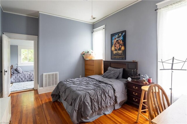 bedroom featuring crown molding and hardwood / wood-style flooring