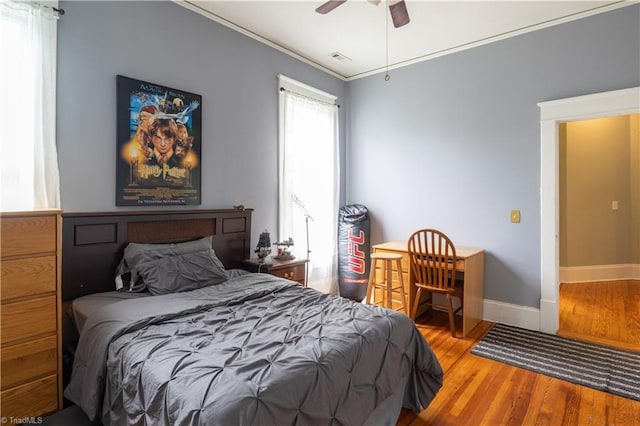 bedroom with ceiling fan, hardwood / wood-style flooring, and ornamental molding