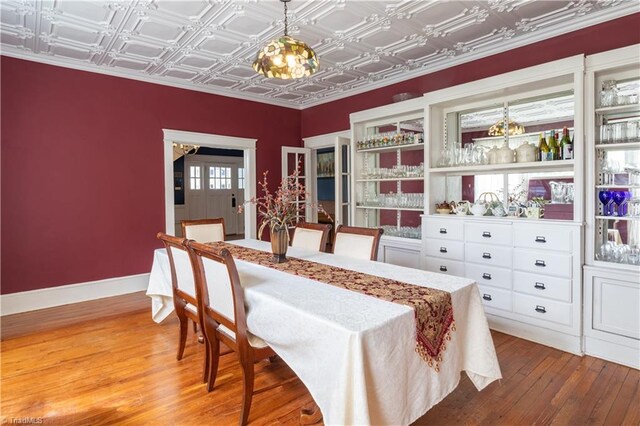 dining room with coffered ceiling and hardwood / wood-style flooring