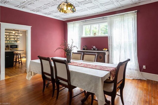 dining area featuring hardwood / wood-style flooring and coffered ceiling