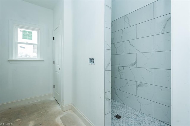 bathroom featuring a tile shower and concrete flooring