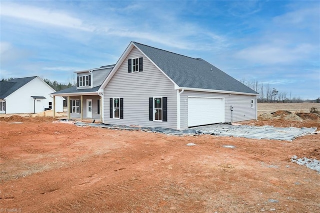 rear view of house featuring a garage and covered porch