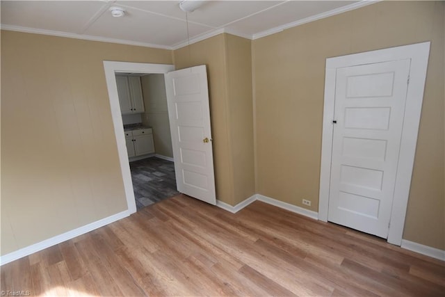 spare room featuring light hardwood / wood-style floors and crown molding