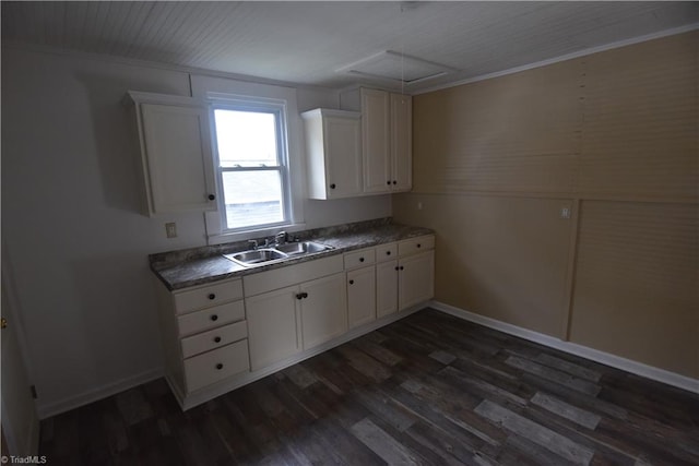 kitchen with white cabinets, dark hardwood / wood-style flooring, ornamental molding, and sink