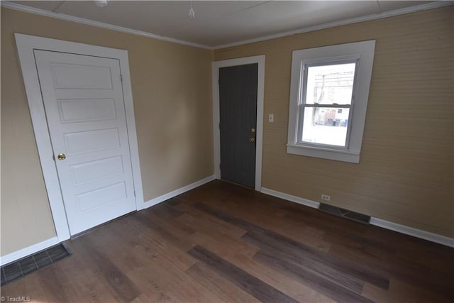 empty room with crown molding and dark wood-type flooring