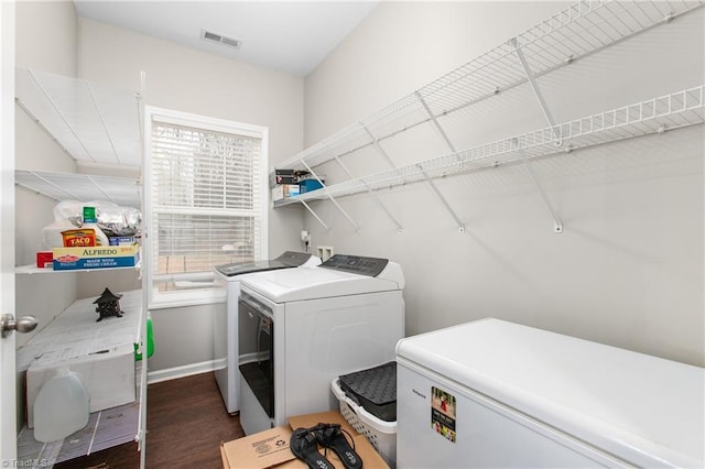 clothes washing area featuring dark wood-type flooring and washer and dryer