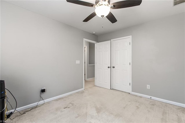 unfurnished bedroom with light colored carpet and ceiling fan