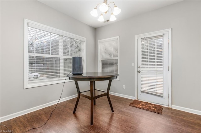 office with hardwood / wood-style floors and an inviting chandelier