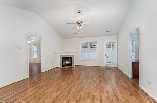unfurnished living room with a ceiling fan, visible vents, vaulted ceiling, and light wood-type flooring