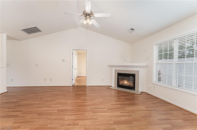 unfurnished living room with a ceiling fan, vaulted ceiling, light wood-type flooring, and visible vents