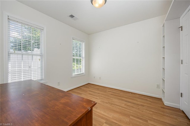 interior space featuring baseboards, plenty of natural light, light wood finished floors, and visible vents