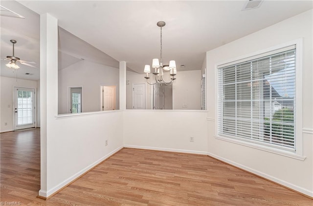 unfurnished dining area featuring baseboards, ceiling fan with notable chandelier, light wood-type flooring, and visible vents