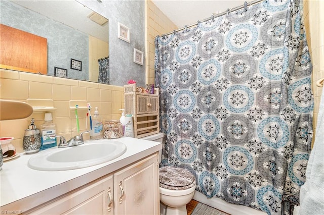 bathroom featuring vanity, backsplash, walk in shower, tile walls, and toilet