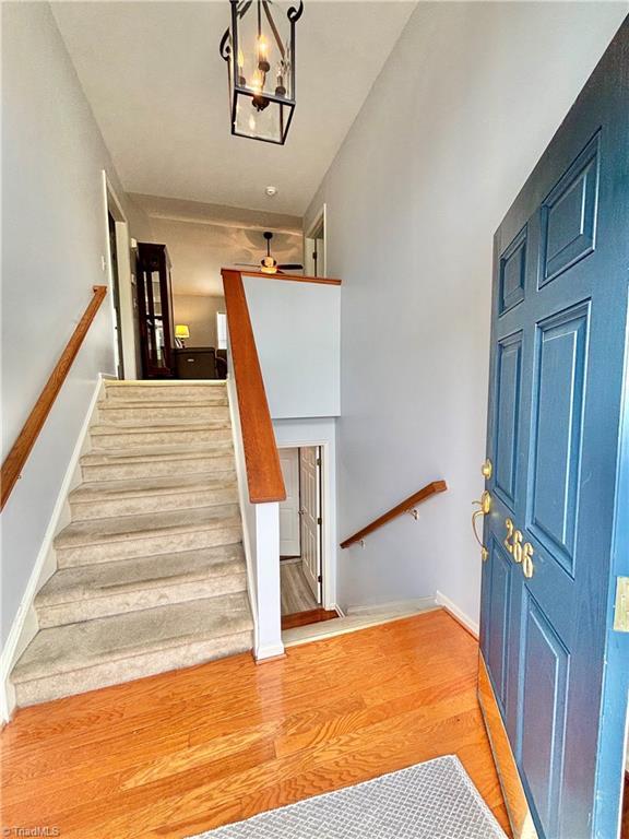 266 Sailway Rd, Winston-Salem, NC 27127 - stairs featuring wood finished floors, a ceiling fan, baseboards, and a chandelier