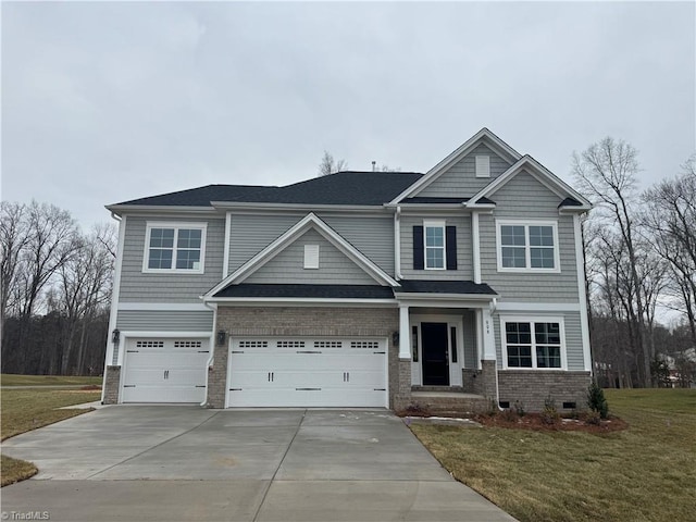 craftsman-style home with an attached garage, driveway, a front lawn, and brick siding