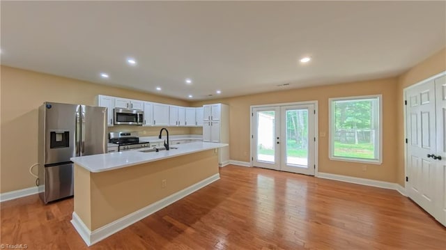 2209 Bracyridge Rd, Greensboro, NC 27407 - kitchen featuring appliances with stainless steel finishes, a sink, baseboards, light wood-style flooring, and recessed lighting