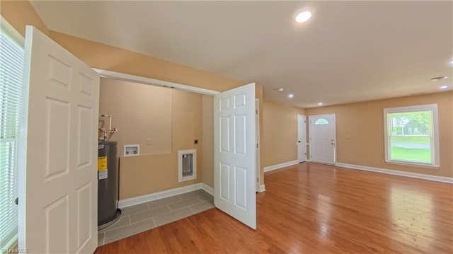 2209 Bracyridge Rd, Greensboro, NC 27407 - laundry room featuring hookup for a washing machine, electric water heater, electric dryer hookup, light wood finished floors, and baseboards