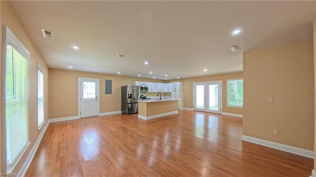2209 Bracyridge Rd, Greensboro, NC 27407 - unfurnished living room with light wood-type flooring, a sink, baseboards, and recessed lighting