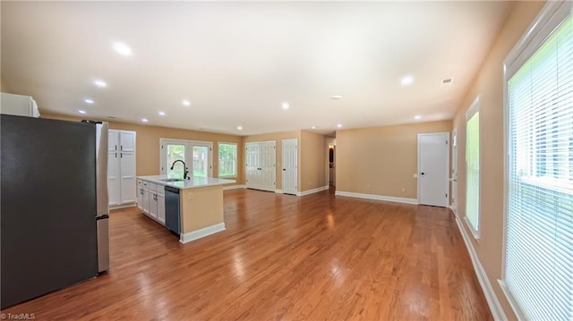 2209 Bracyridge Rd, Greensboro, NC 27407 - kitchen featuring freestanding refrigerator, a sink, dishwashing machine, light countertops, and light wood-style floors