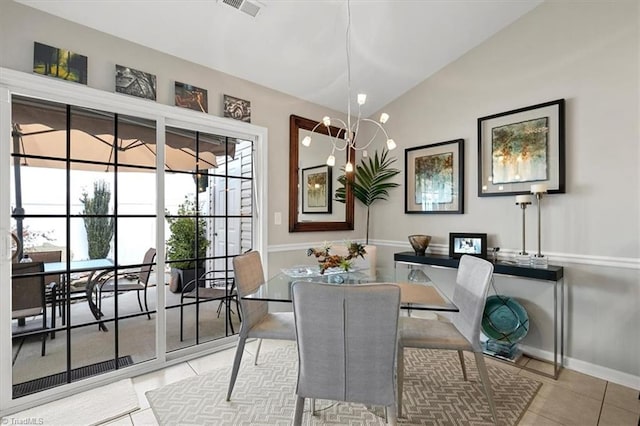 dining room with light tile patterned flooring, a notable chandelier, and vaulted ceiling