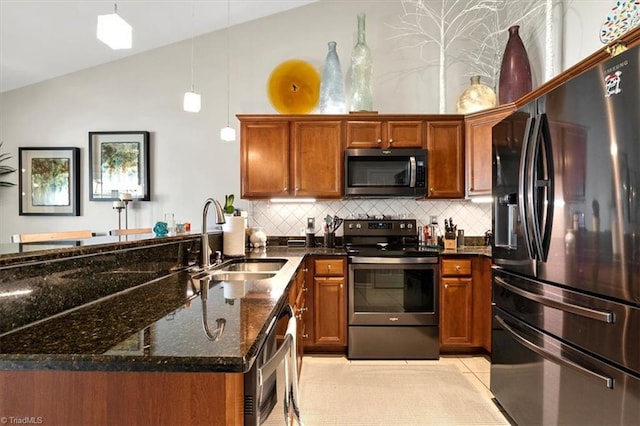 kitchen with lofted ceiling, dark stone countertops, tasteful backsplash, light tile patterned floors, and stainless steel appliances