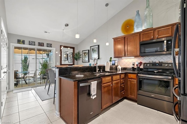 kitchen with tasteful backsplash, stainless steel appliances, pendant lighting, sink, and light tile patterned floors