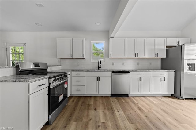 301 Rockspring Rd, High Point, NC 27262 - kitchen featuring stainless steel appliances, light wood-type flooring, white cabinetry, a peninsula, and light stone countertops