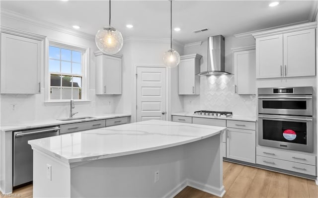700 Fairmile Dr, Greensboro, NC 27455 - kitchen featuring a sink, stainless steel appliances, wall chimney exhaust hood, light wood finished floors, and a kitchen island