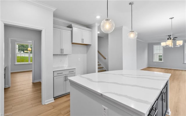 700 Fairmile Dr, Greensboro, NC 27455 - kitchen featuring a kitchen island, light wood-style flooring, ornamental molding, hanging light fixtures, and light stone countertops