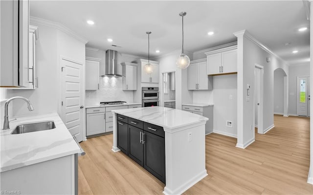 700 Fairmile Dr, Greensboro, NC 27455 - kitchen with wall chimney exhaust hood, a sink, arched walkways, stainless steel appliances, and crown molding