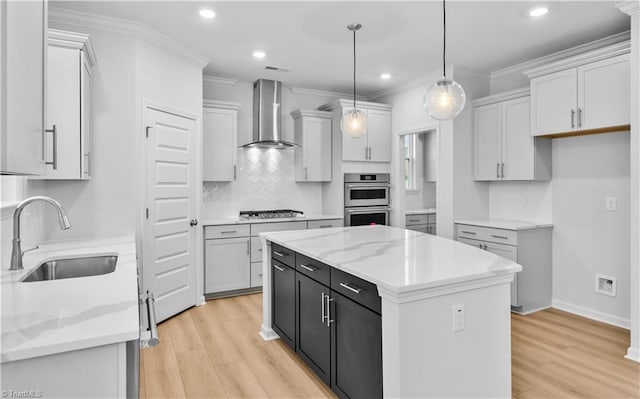 700 Fairmile Dr, Greensboro, NC 27455 - kitchen with a sink, wall chimney exhaust hood, appliances with stainless steel finishes, light wood-style flooring, and a kitchen island