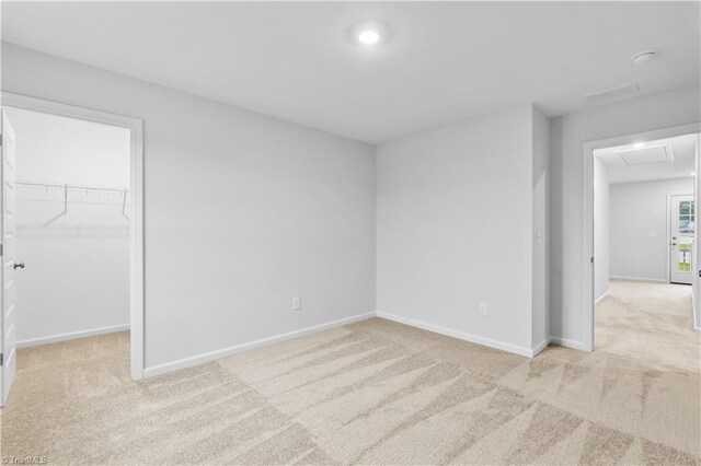700 Fairmile Dr, Greensboro, NC 27455 - unfurnished bedroom with light colored carpet, a walk in closet, baseboards, a closet, and recessed lighting
