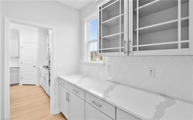 700 Fairmile Dr, Greensboro, NC 27455 - kitchen with light wood-style floors, light stone counters, white cabinets, and tasteful backsplash