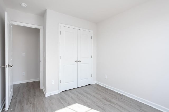 unfurnished bedroom featuring a closet and light wood-type flooring