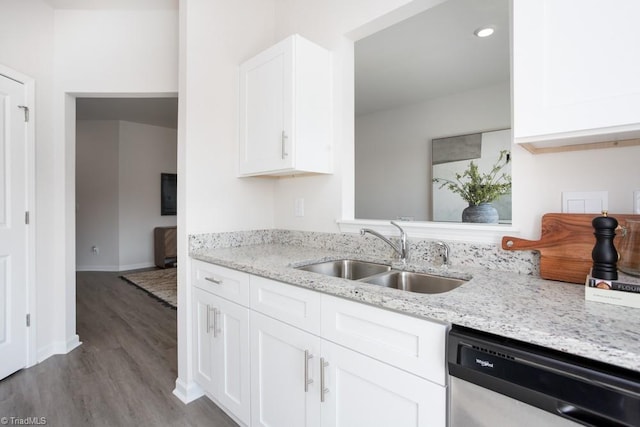 kitchen featuring white cabinets, sink, light hardwood / wood-style flooring, stainless steel dishwasher, and light stone counters