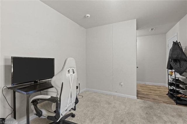 office with baseboards and light colored carpet