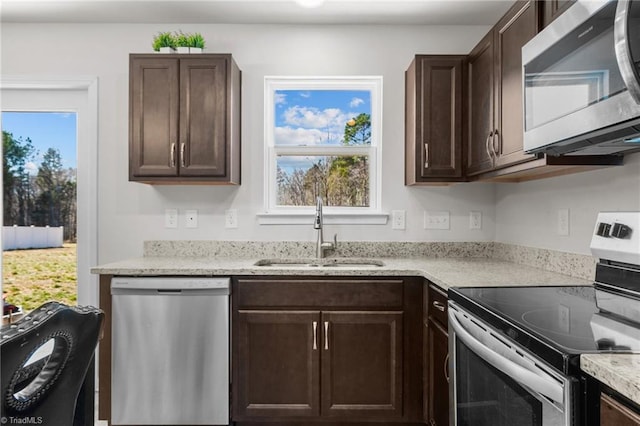 kitchen featuring stainless steel appliances, a sink, and dark brown cabinetry