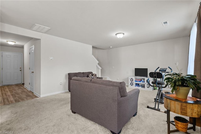 living room featuring light carpet, baseboards, stairs, and visible vents