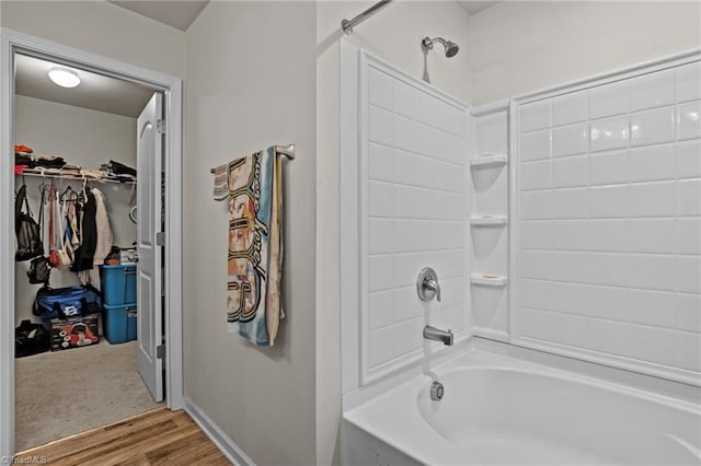 full bathroom with wood finished floors, bathtub / shower combination, and a walk in closet