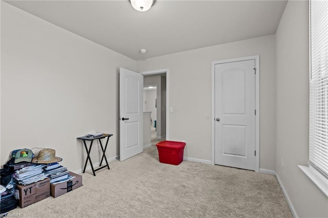 misc room featuring light carpet and baseboards