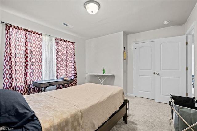 bedroom with carpet floors, a closet, visible vents, and baseboards