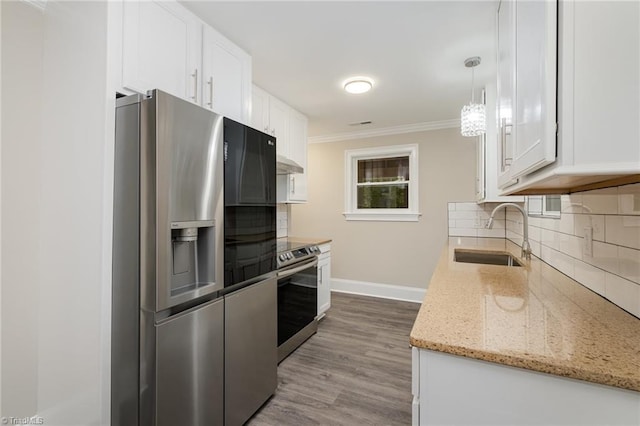 kitchen featuring sink, hardwood / wood-style flooring, decorative light fixtures, white cabinetry, and stainless steel appliances