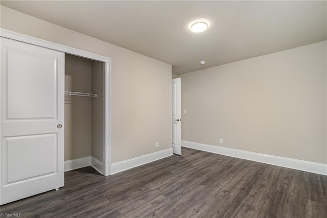 unfurnished bedroom with dark hardwood / wood-style floors and a closet