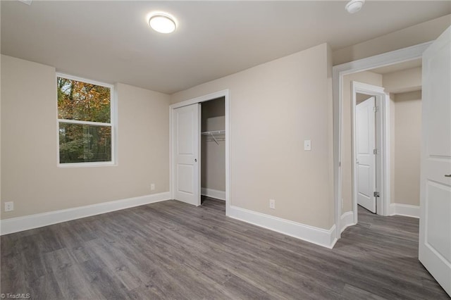 unfurnished bedroom with dark hardwood / wood-style floors and a closet