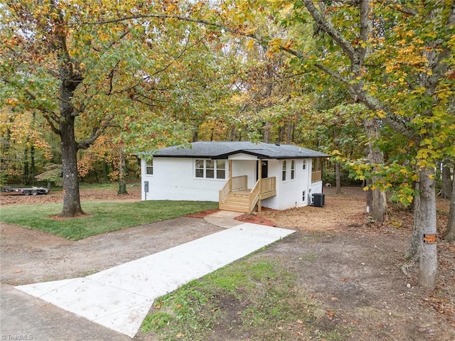 view of front of house with central AC unit and a front yard