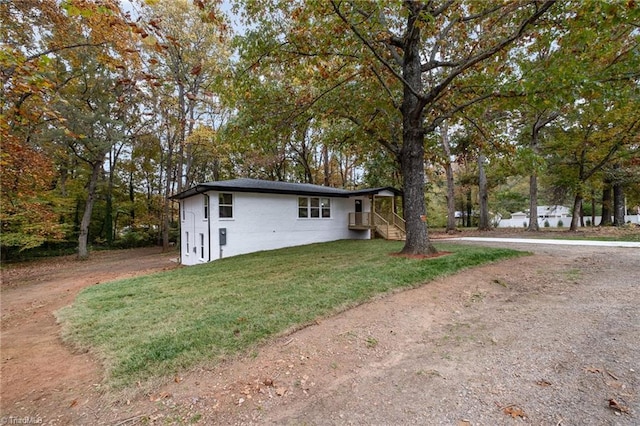 view of side of home with a yard